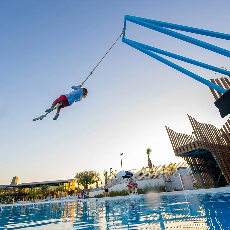 Rope Swing Image of a guest enjoying the rope swing activity at the Blue Hole near Evermore Bay at Evermore Orlando Resort.